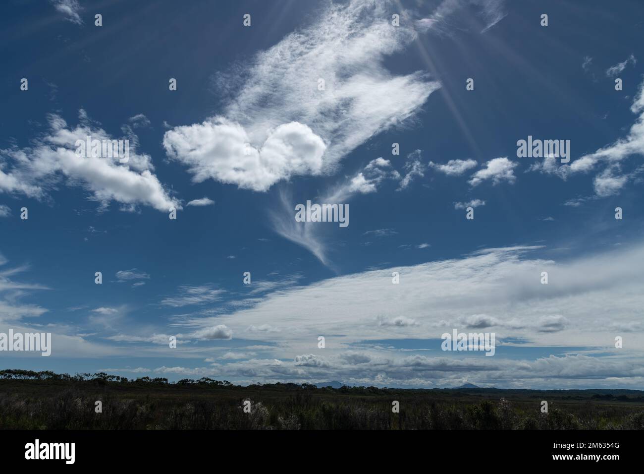 Cloudy blue sky with sunrays. Stock Photo