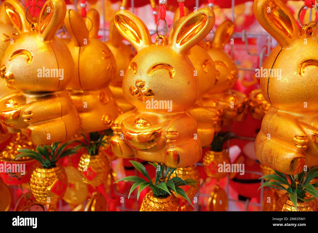 Golden rabbit trinkets and ornaments, sold at a street market to usher