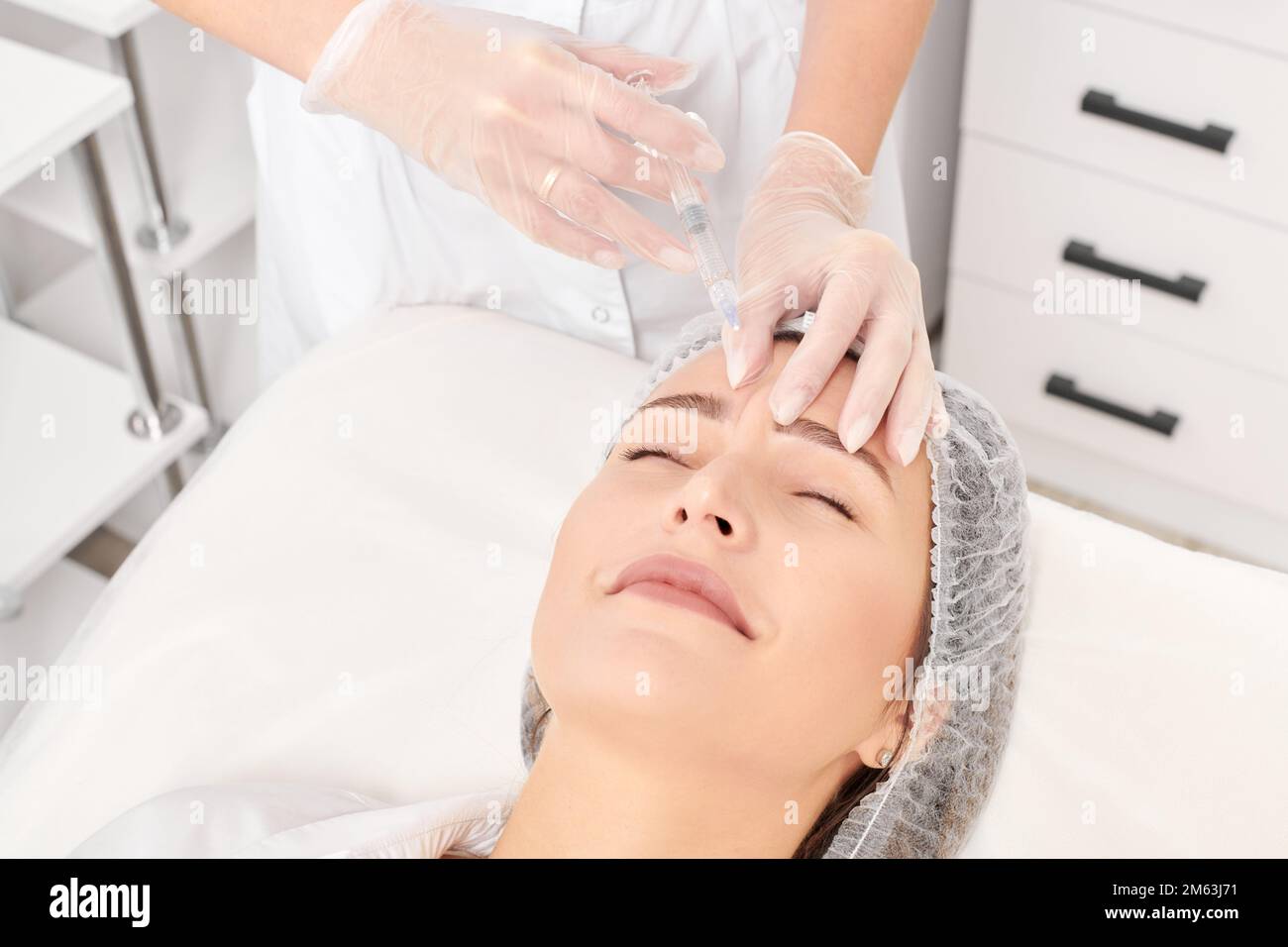 Cosmetologist makes rejuvenation injection in woman face skin, anti ...