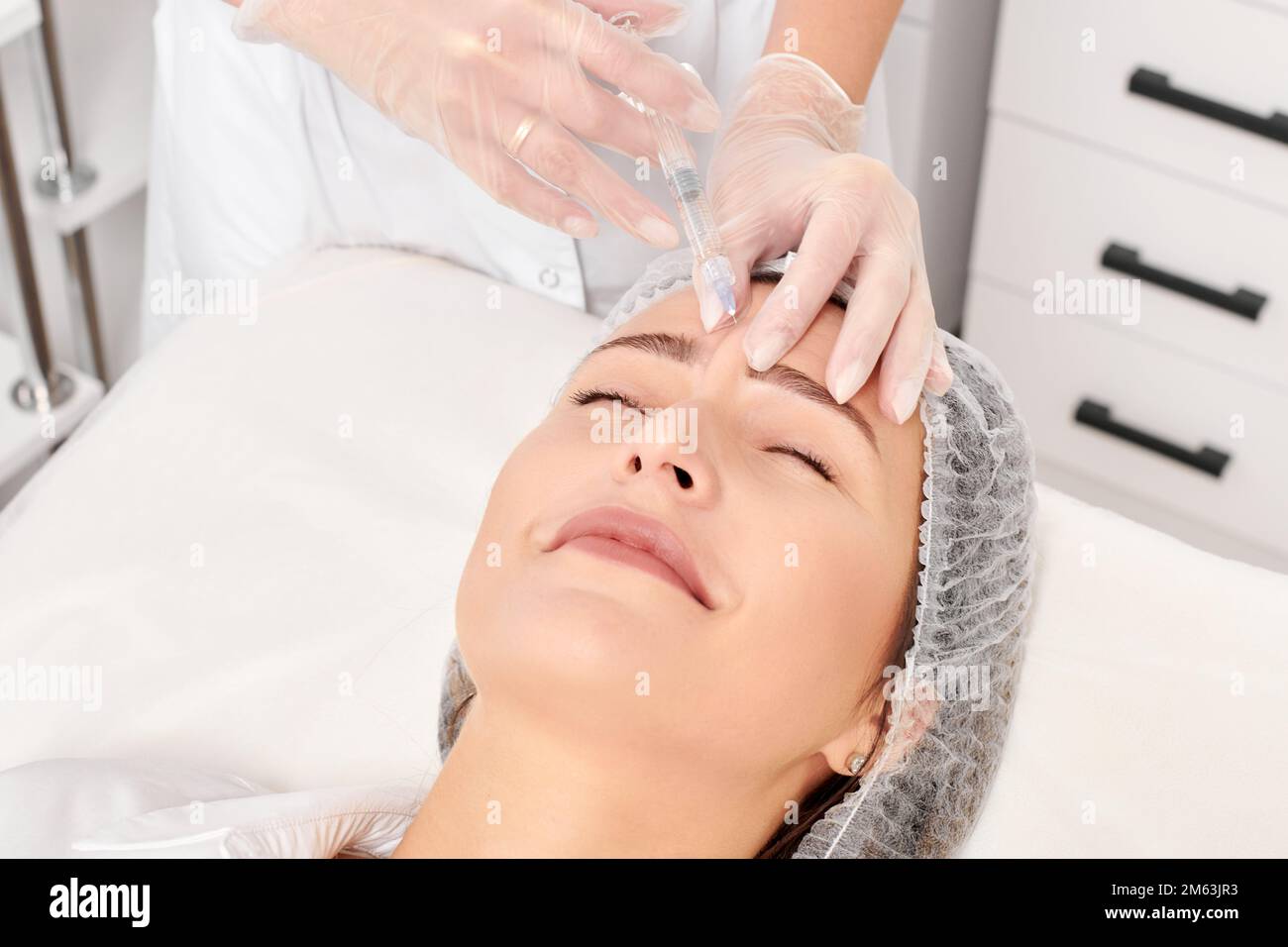 Cosmetologist makes rejuvenation injection in woman face skin, anti ...