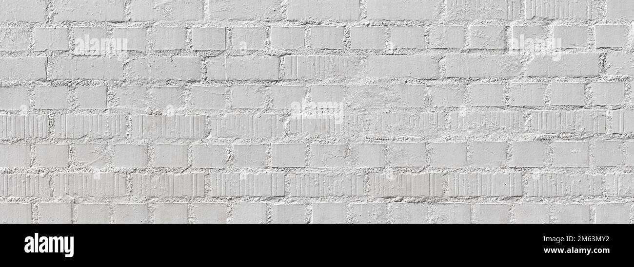 Roughly worked, white painted old brick wall Stock Photo