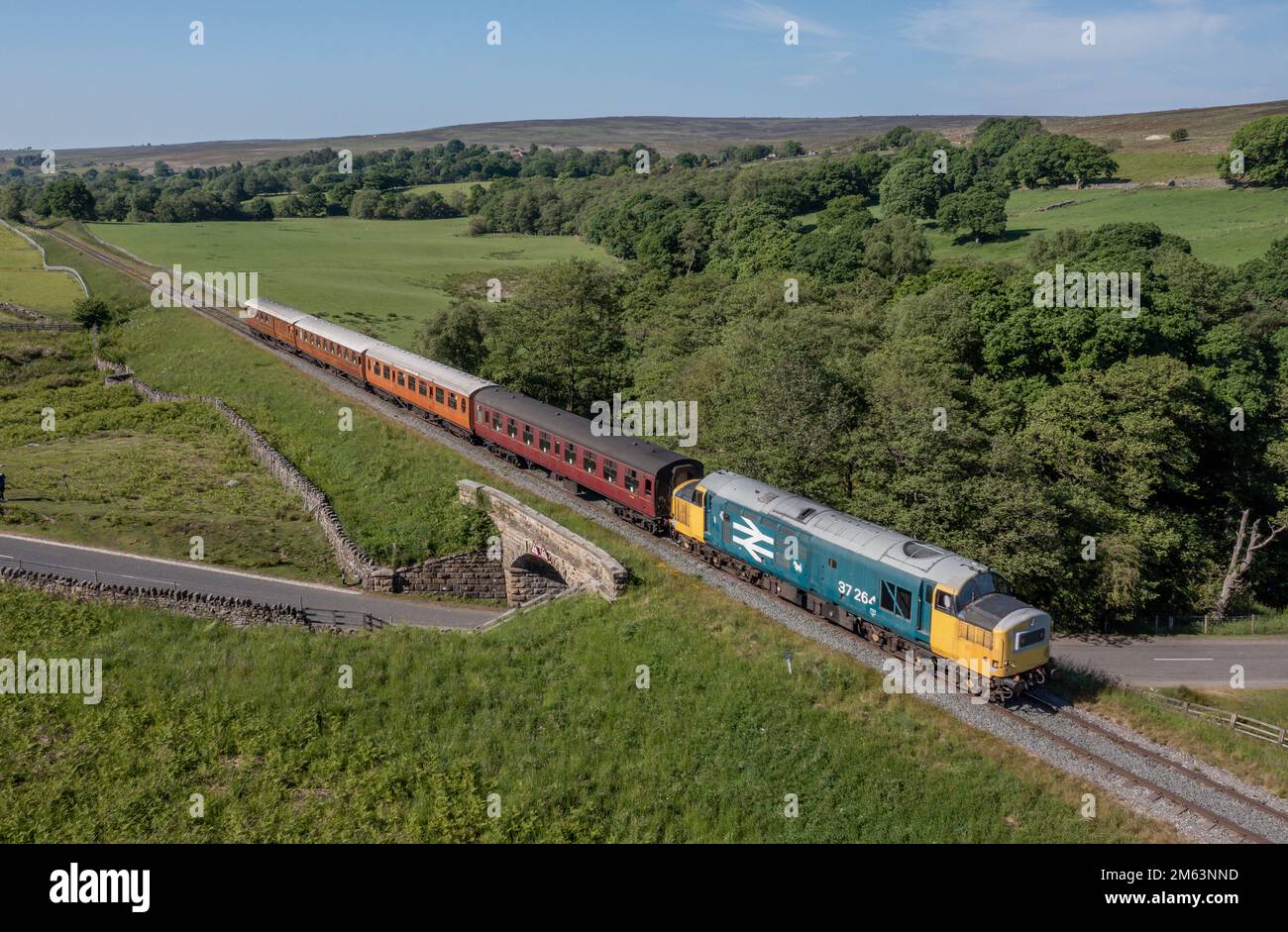 Vintage Diesel train locomotive pulling carriages and passengers on the North Yorkshire Moors Railway between Whitby and Pickering Stock Photo