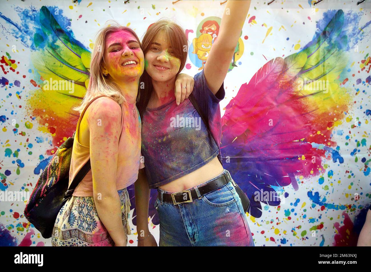 Young people, teenagers and adults celebrate the Holi event in Ukraine in Chernivtsi on March 8. They have fun and throw paint at each other. High quality photo Stock Photo