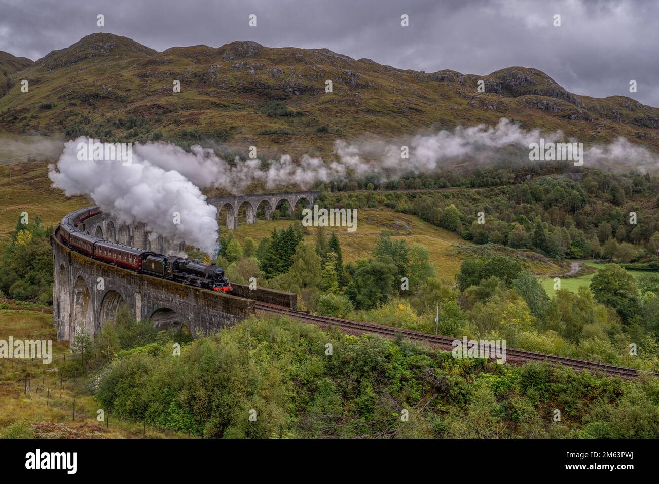 steam train crossing the Glenfinnan Railway Viaduct, a famous bridge in the Scottish highlands