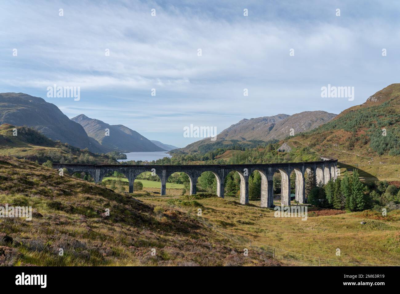 Glenfinnan Railway Viaduct in the Scottish Highlands, Scotland. famous arched viaduct used by steam trains in the mountains. Aerial view with loch Stock Photo