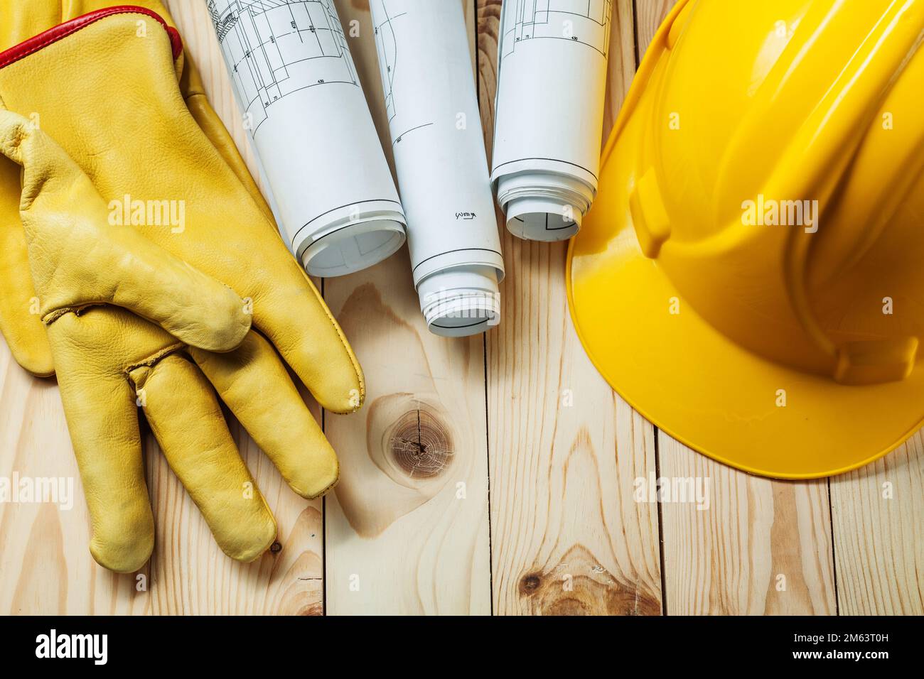 yellow gloves blueprints and construction helmet on wood Stock Photo ...