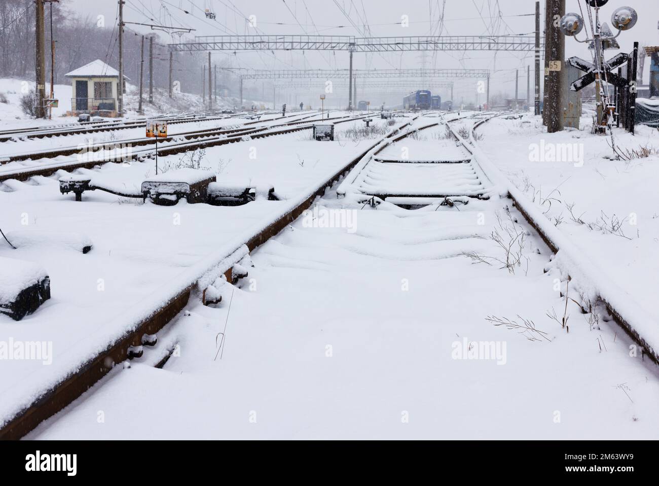 Automatic arrow of the railway tracks covered with snow on a winter day. Copy space. Stock Photo