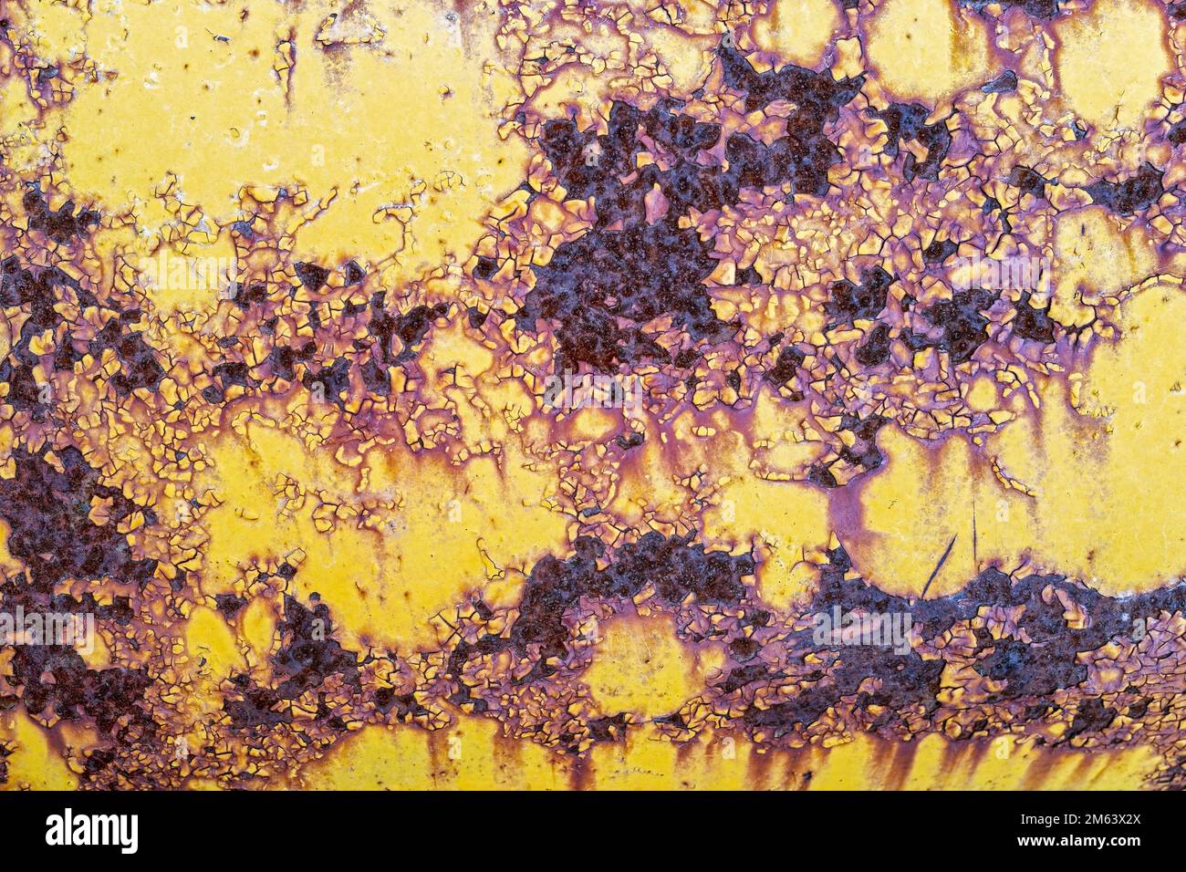 Rust and peeling yellow paint on the surface of an antique tractor Stock Photo