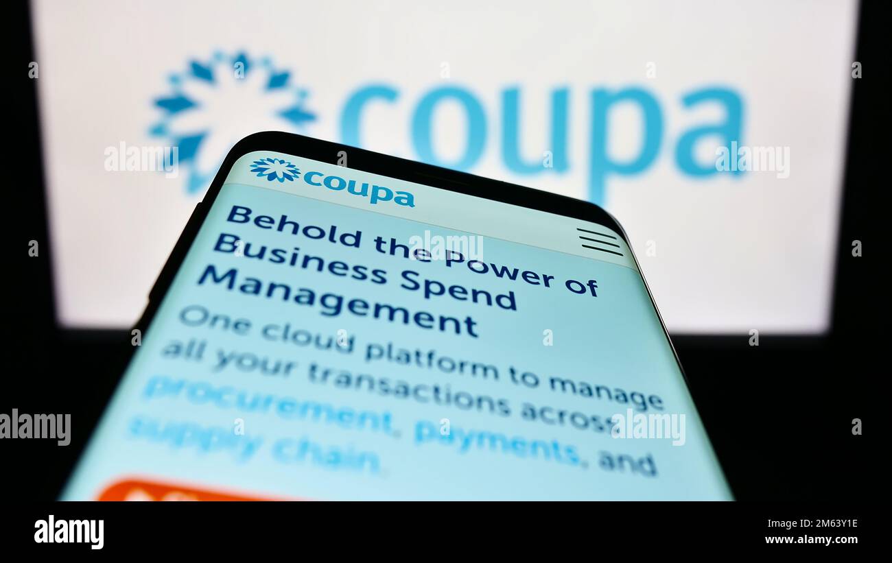 Smartphone with website of spend management company Coupa Software Inc. on screen in front of business logo. Focus on top-left of phone display. Stock Photo
