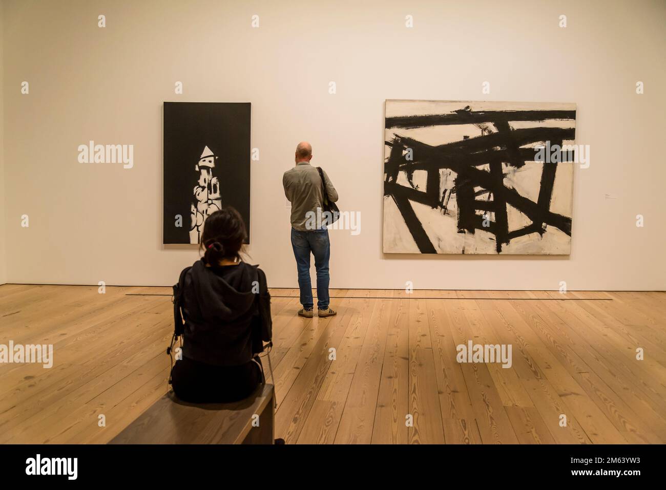 Visitor between Norman Lewis painting American Totem,1960, and Franz Kline painting Mahoning, 1956, Whitney Museum of American Art, focusing on 20th- Stock Photo