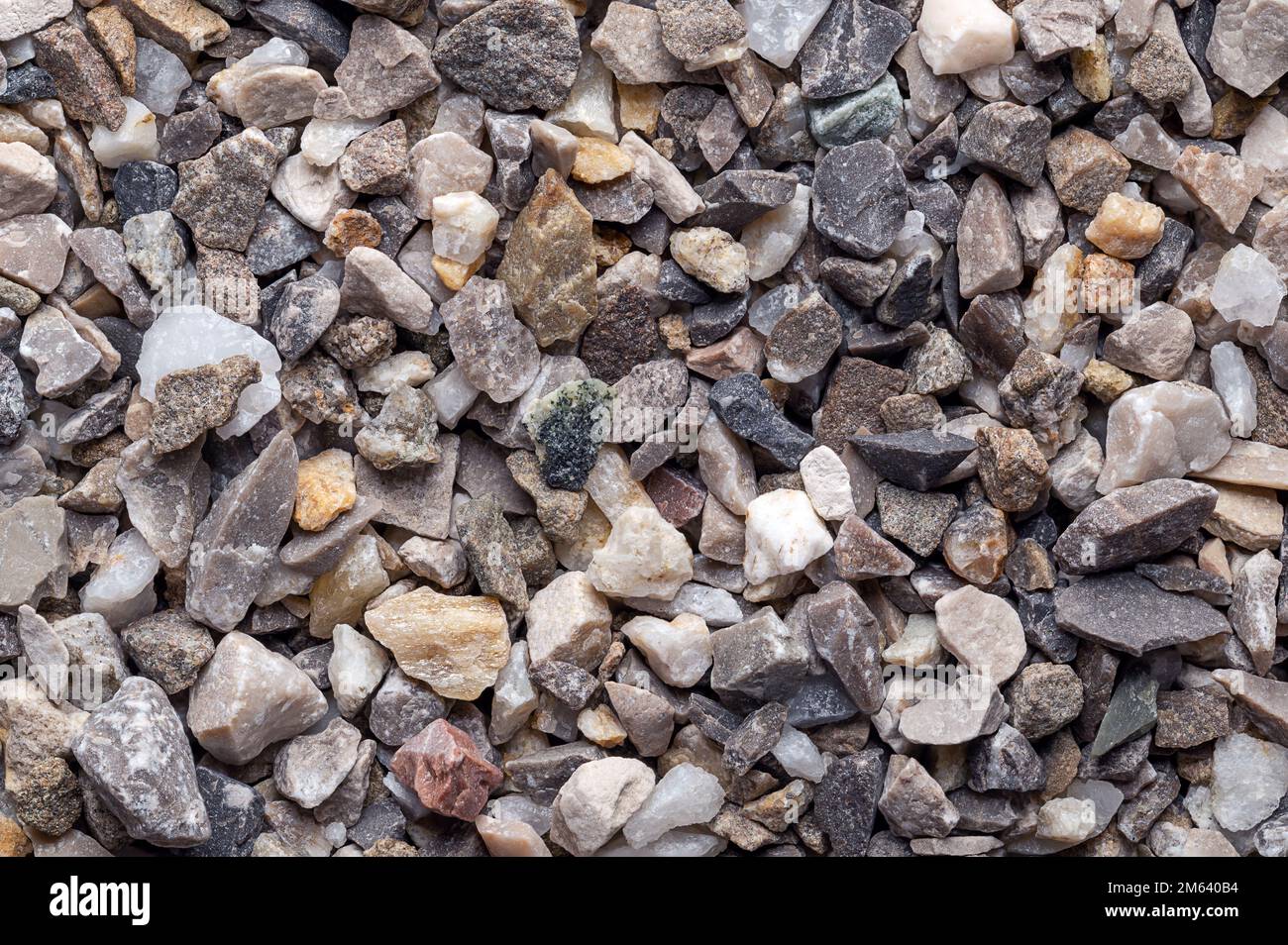 Road and plaster grit, loose chippings, crushed stone, surface, macro photo. Dry lime- and iron-free quartz sand, used as spreading grit. Stock Photo