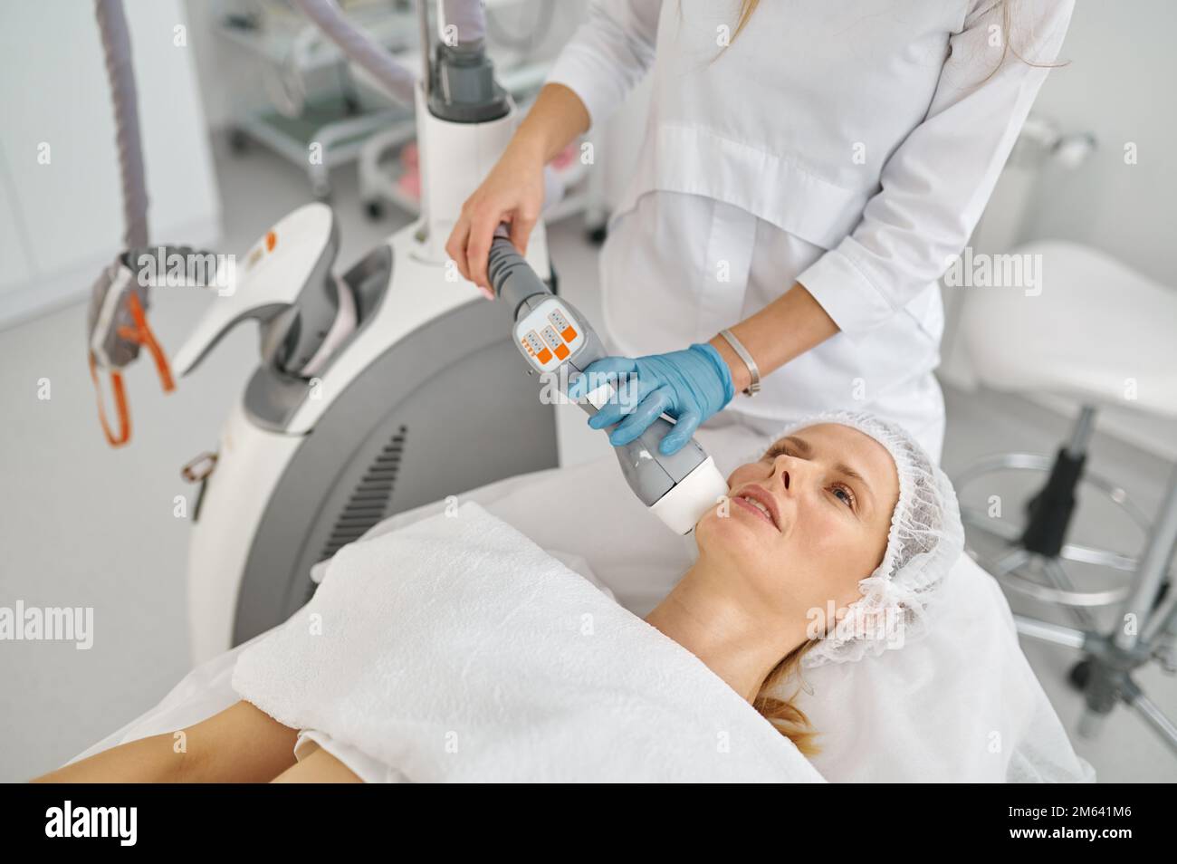 Doctor cosmetologist doing face apparatus massage Stock Photo
