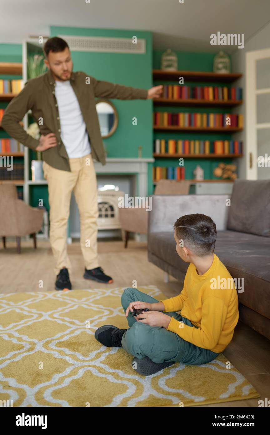 Parent scolding child addicted to modern technologies at home Stock Photo