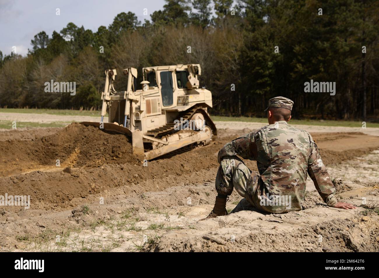 Pfc. Troy Wooten, a horizontal construction engineer assigned to 24th Ordnance Company, 87th Division Sustainment Support Battalion, 3rd Division Sustainment Brigade, 3rd Infantry Division, waits to operate the bulldozer during a three-day exercise to train on the construction of the field Ammunition Supply Points on March 30, 2022, on Fort Stewart, Georgia. Stock Photo