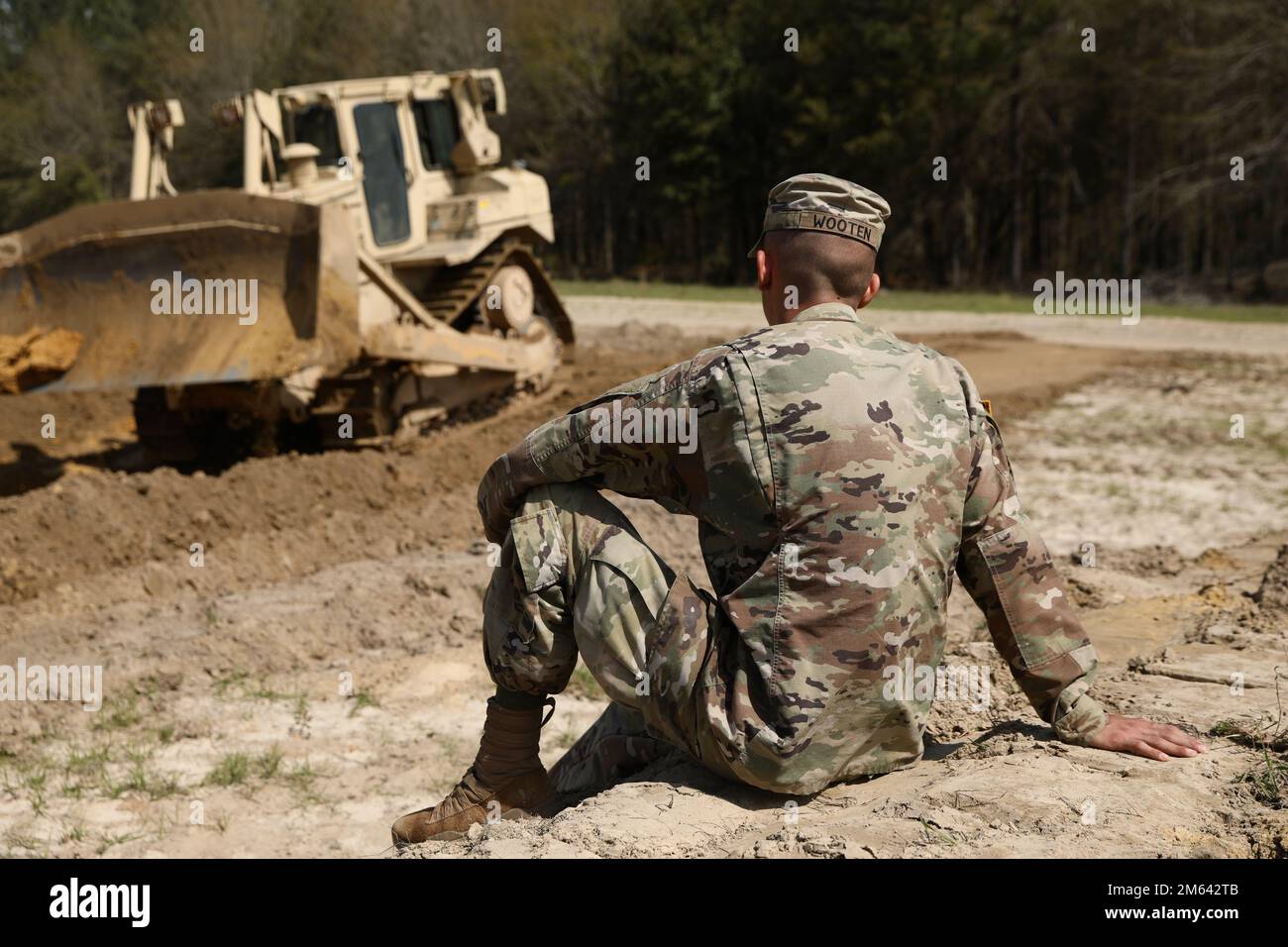 Pfc. Troy Wooten, a horizontal construction engineer assigned to 24th Ordnance Company, 87th Division Sustainment Support Battalion, 3rd Division Sustainment Brigade, 3rd Infantry Division, waits to operate the bulldozer during a three-day exercise to train on the construction of the field Ammunition Supply Points on March 30, 2022, on Fort Stewart, Georgia. Stock Photo