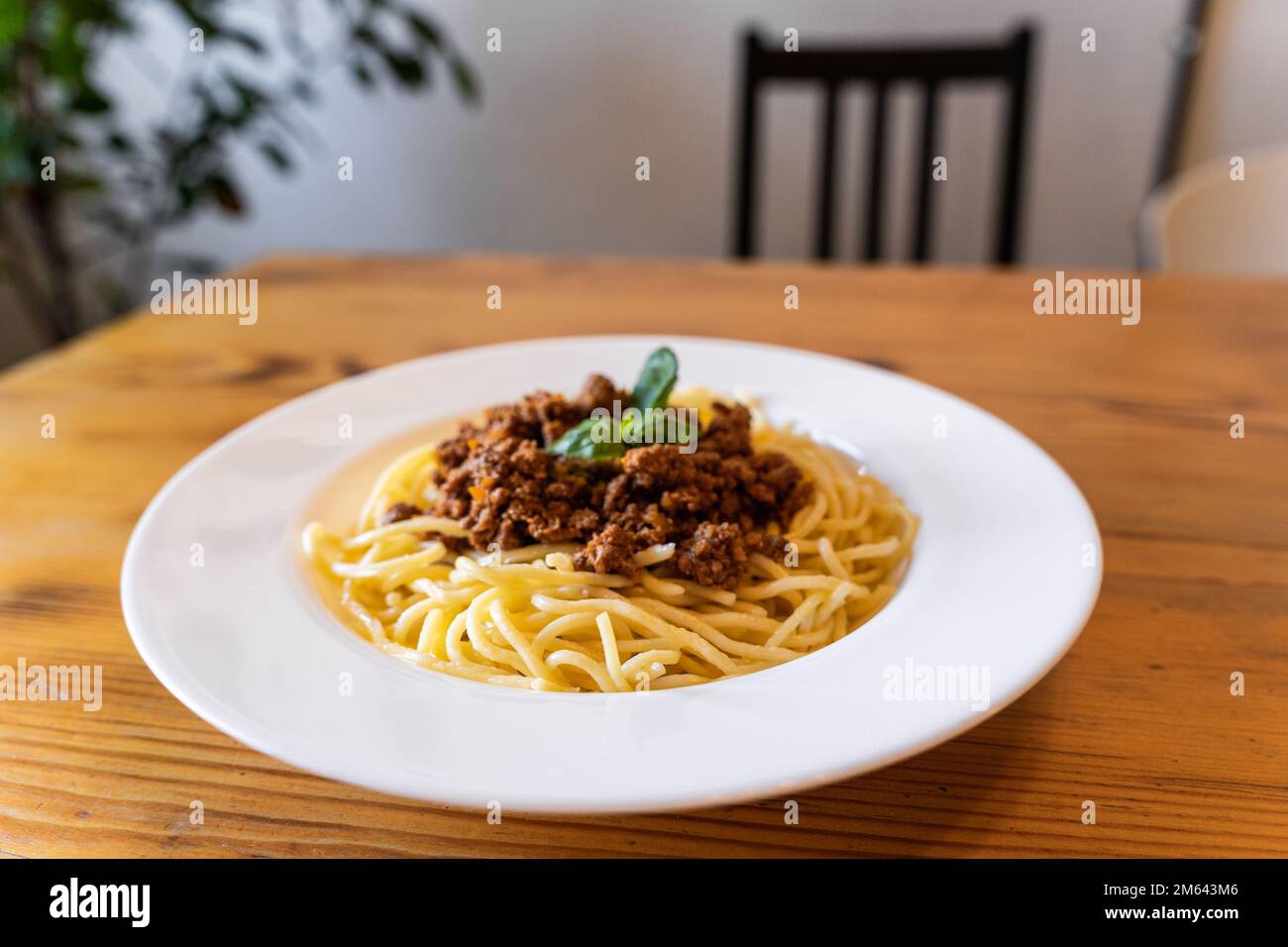 Plate with traditional Italian pasta spaghetti bolognese on a wooden table in the restaurant Stock Photo