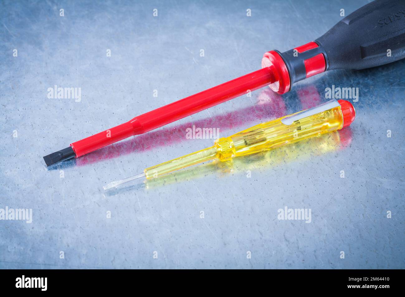 Insulated electric screwdrivers tester on scratched metallic surface