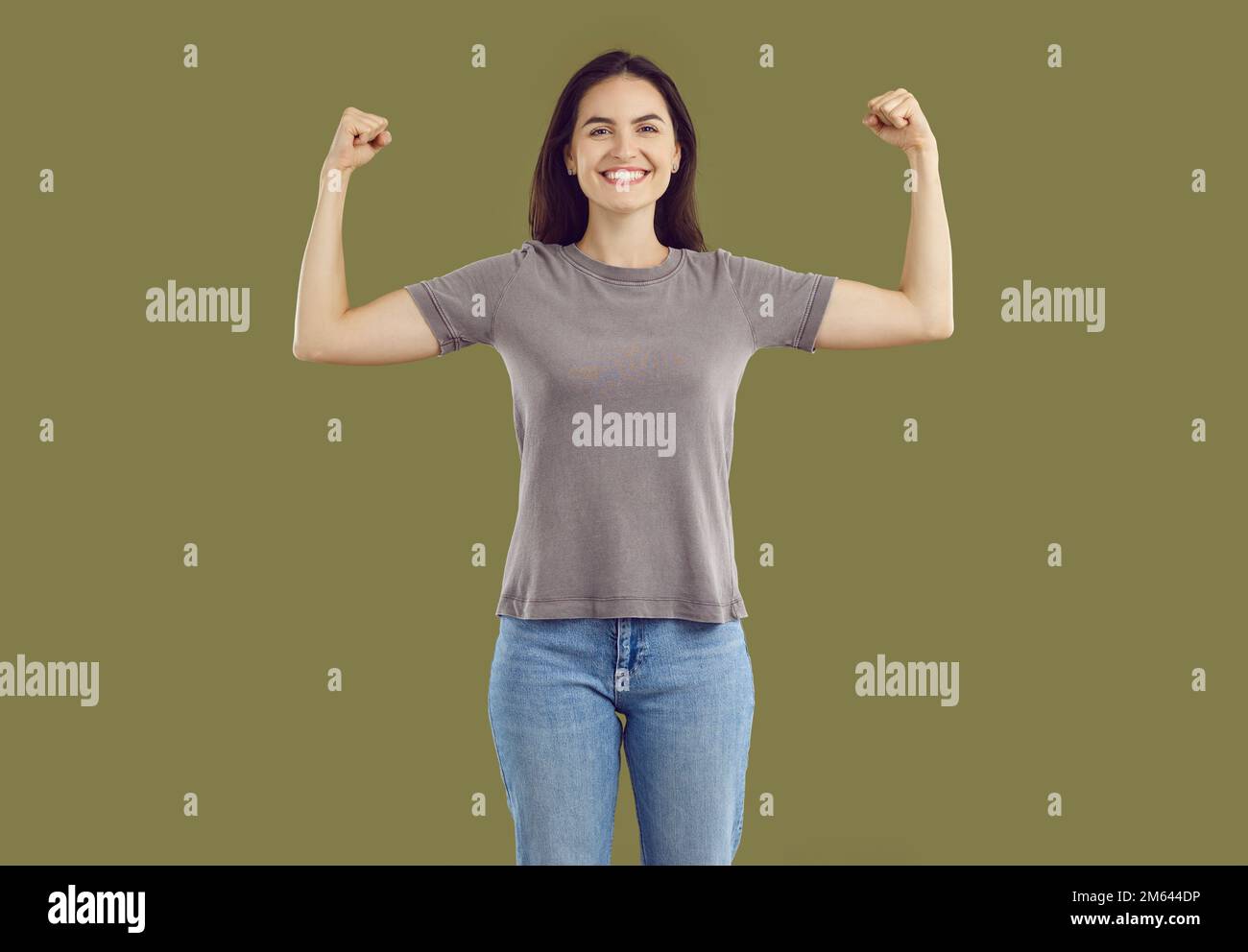 Smiling strong powerful young woman showing her biceps Stock Photo
