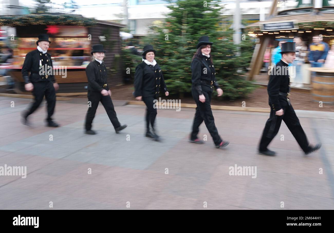 02 January 2023, Saxony, Chemnitz: Chimney sweeps from the Saxon Chimney Sweep Guild walk along a shopping mall. In a shopping mall, more than 30 men and women of the chimney sweep trade hand out lucky charms to customers and passers-by to mark the start of the year. Photo: Sebastian Willnow/dpa Stock Photo