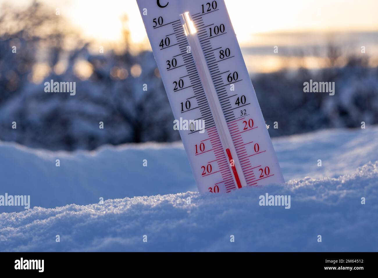 Thermometer on snow shows low temperatures in celsius or farenheit. On