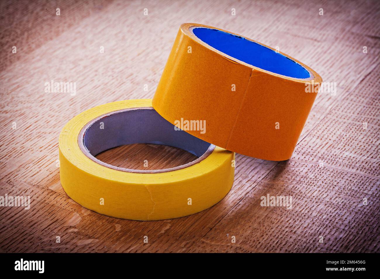 Narrow and wide duct tapes on vintage brown wooden board maintenance