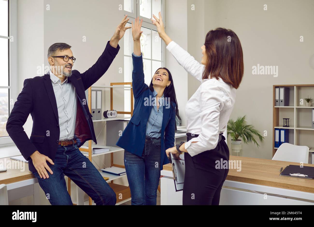 Happy successful business team giving high five celebrating achievement ...