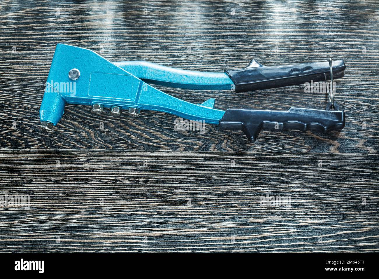 Riveting pliers on wooden board. Stock Photo