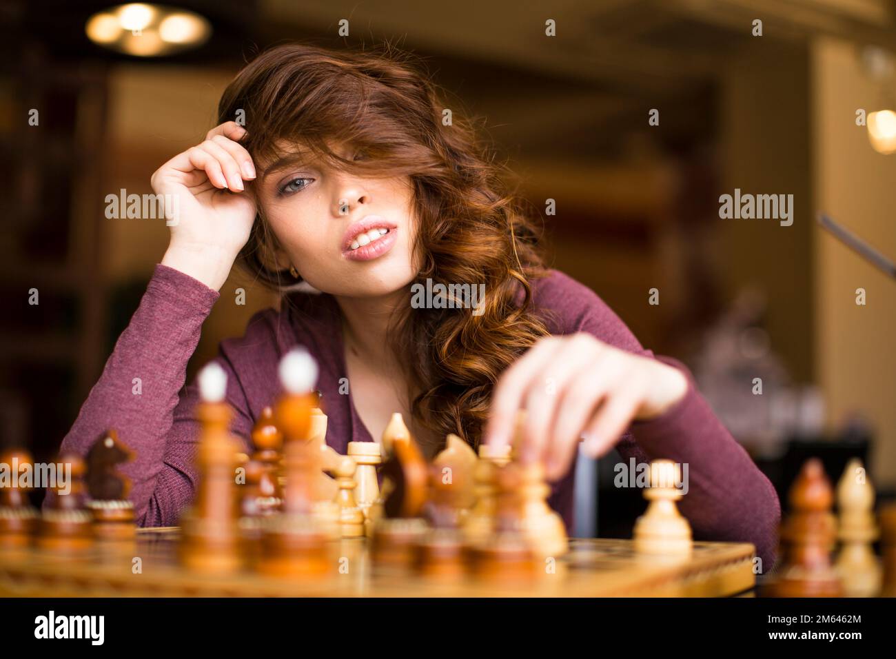 Woman playing chess thinking of next move Stock Photo - Alamy