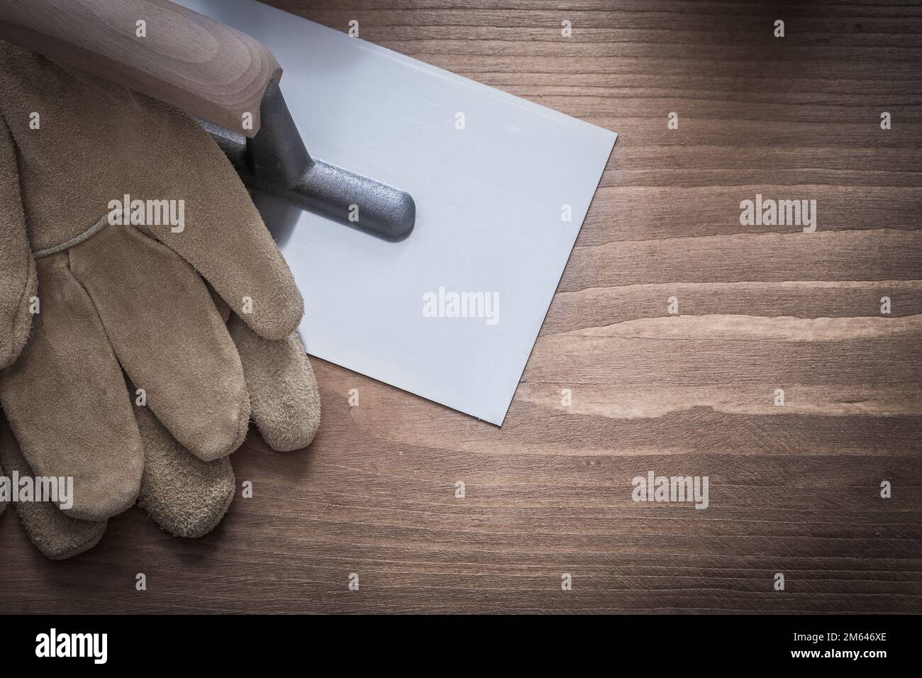 Safety gloves and glossy plastering trowel construction concept. Stock Photo