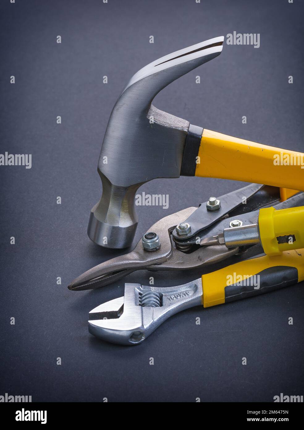 screwdriver claw hammer adjustable wrench with yellow handles on black