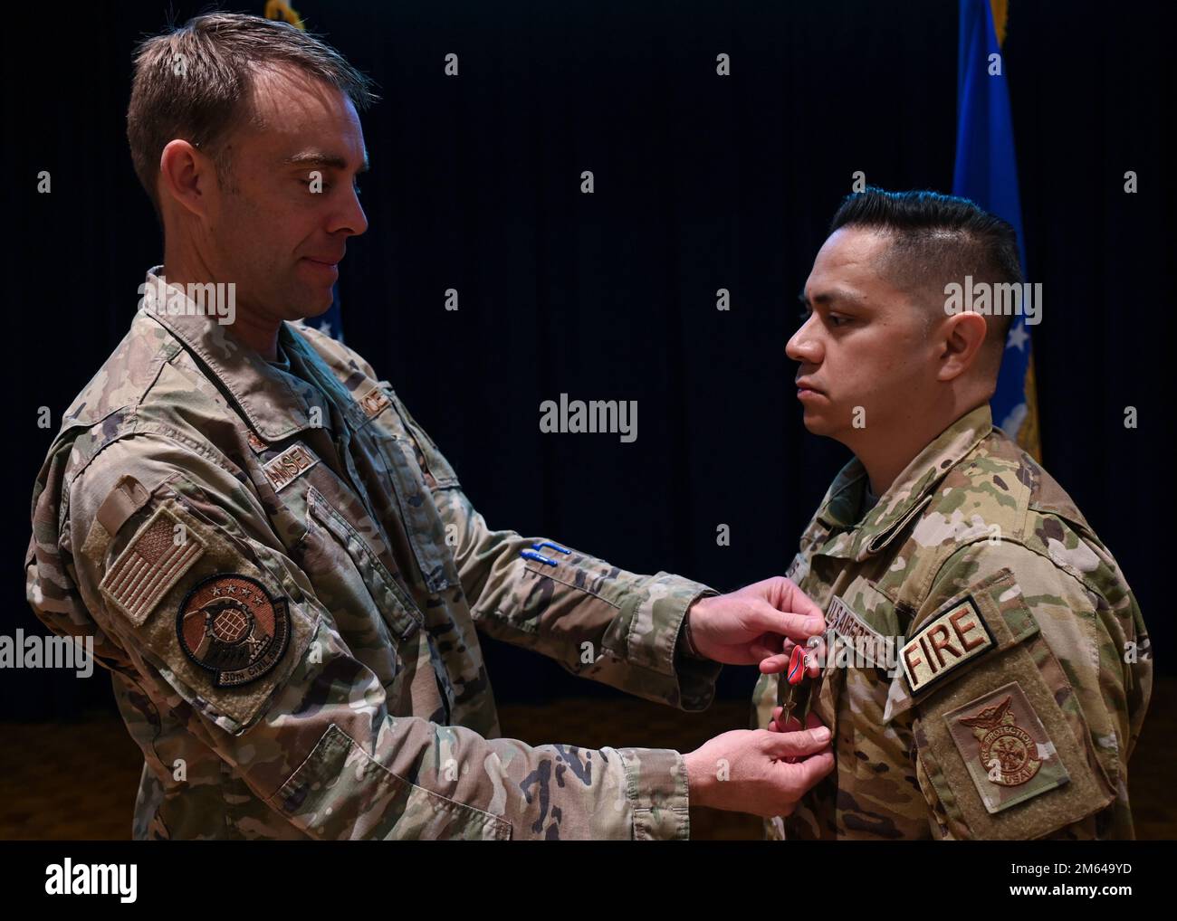 Lt. Col. Charles Hansen, 30th Civil Engineer Squadron commander, presents a Bronze Star Medal to Master Sgt. Roy Campos, 30th Civil Engineer Squadron readiness division chief on Vandenberg Space Force Base, Calif., March 31, 2022. Campos directed immediate action that moved his team into defensive fighting positions to maintain perimeter security for over eight hours, and directed 22 emergency responses with one of them being outside the controlled perimeter while exposed to enemy forces. Stock Photo