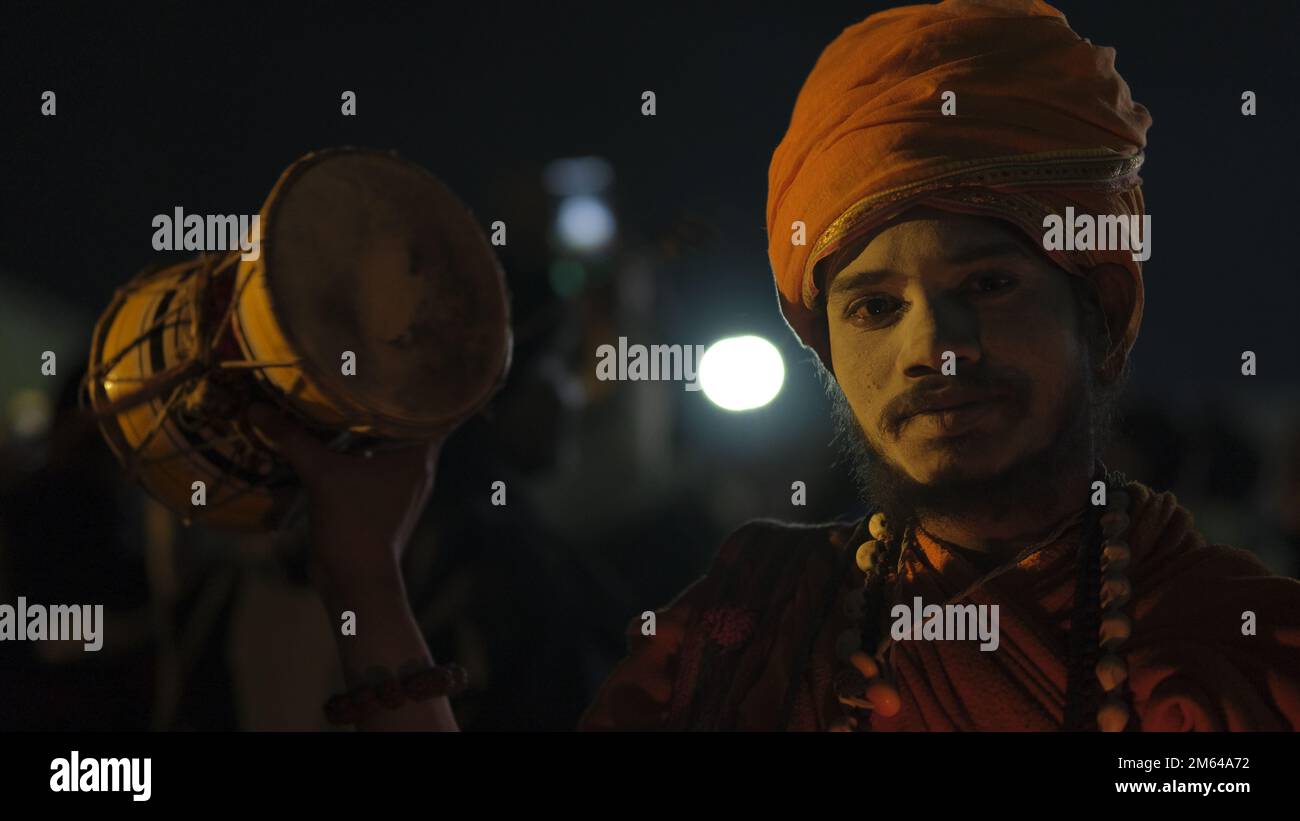 An Indian man holding a drum while smiling Stock Photo