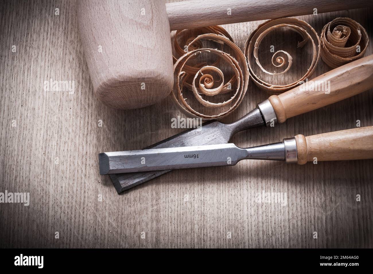 Wooden mallet scobs firmer chisels on wood surface horizontal view construction concept. Stock Photo