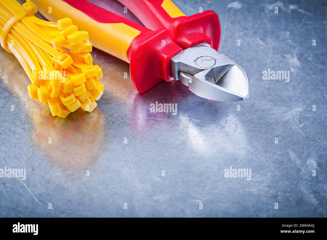 Wire-cutter cable ties on metallic background construction concept. Stock Photo