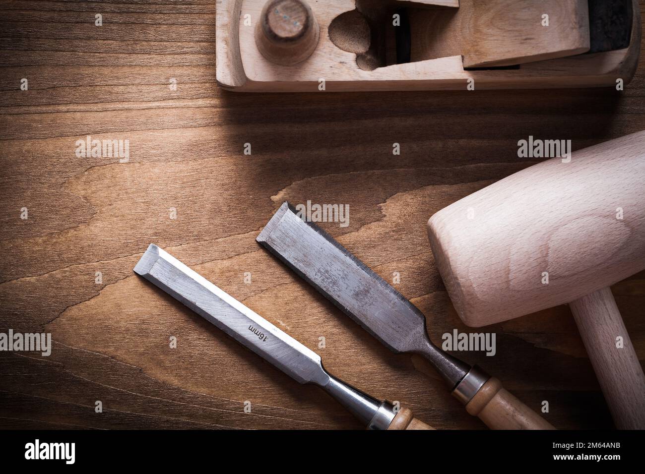 Wooden mallet shaving plane firmer chisels on wood board construction concept. Stock Photo