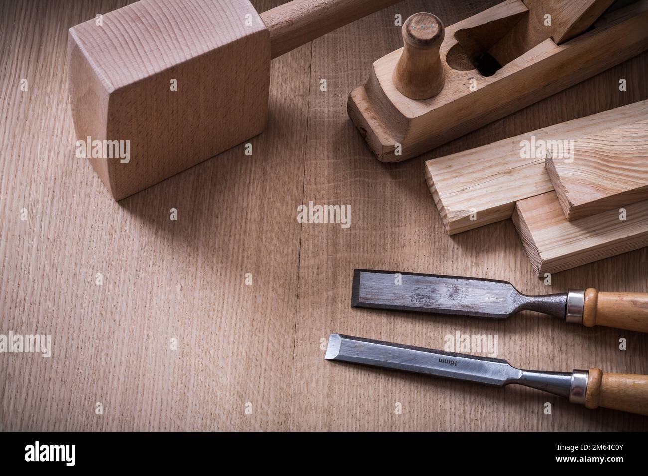 Hand mallet planer metal chisels and wooden stud on wood board construction concept. Stock Photo