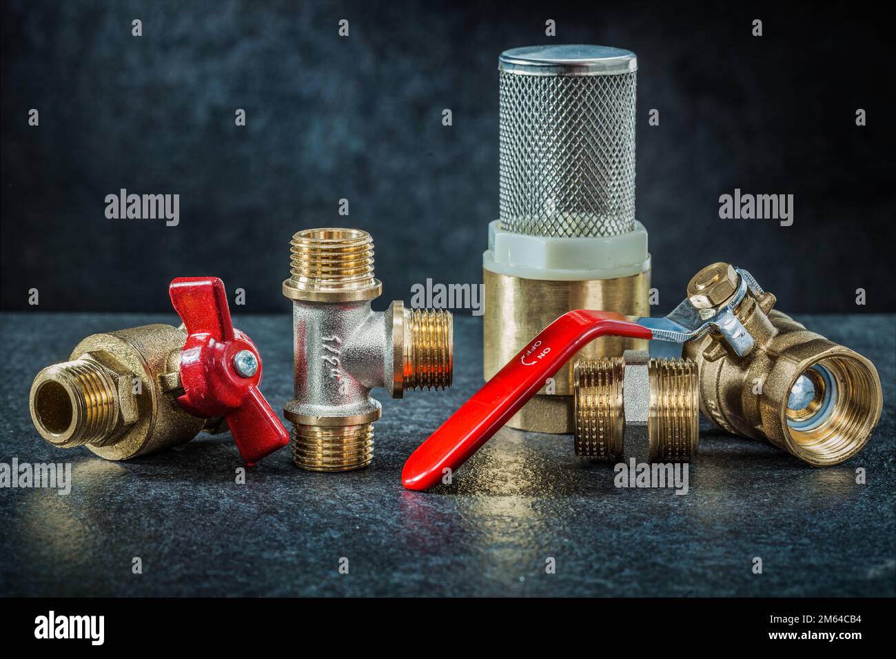 set of brass pipe connectors ondark background Stock Photo