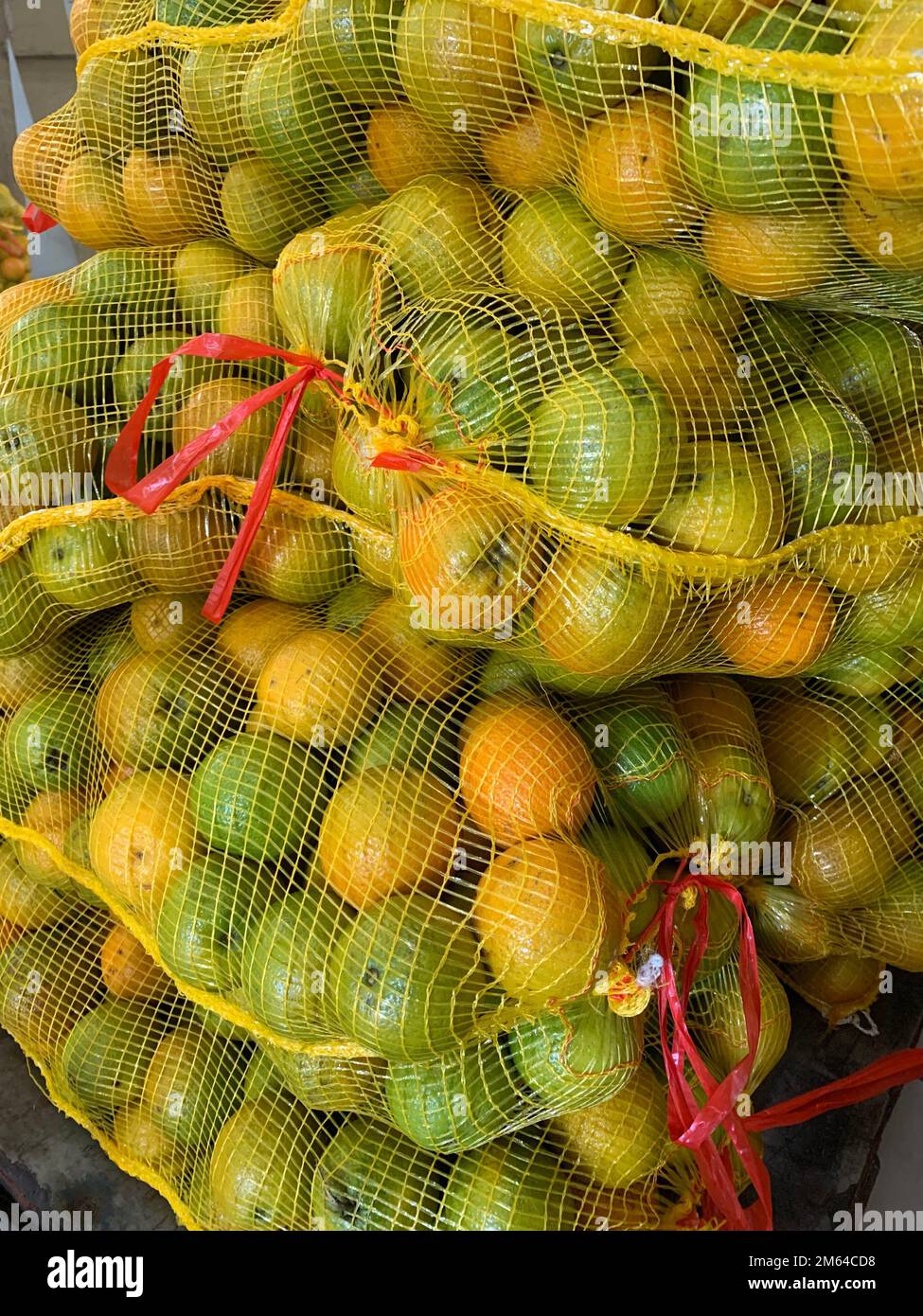 Yellow mesh bags of oranges pilled up on pallet Stock Photo Alamy