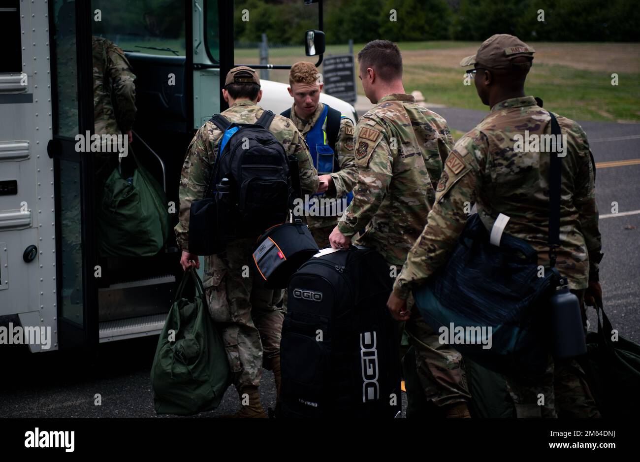 Airmen from the 305th Air Mobility Wing load into a bus after being ...