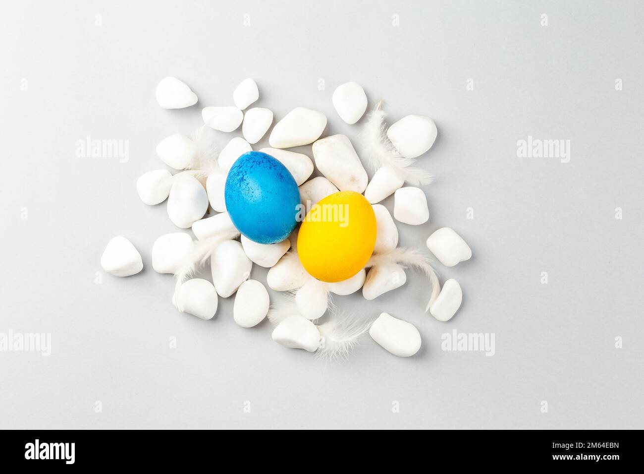 Ukrainian Easter Eggs painted Blue and Yellow on white rocks over gray ...