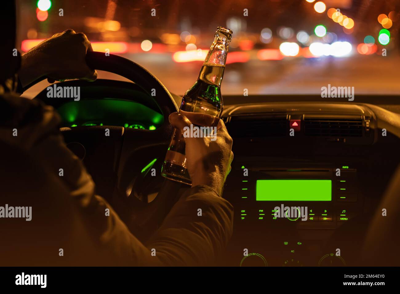 Drinking beer while driving car. Man hold bottle alcohol in hand at the night Stock Photo Alamy
