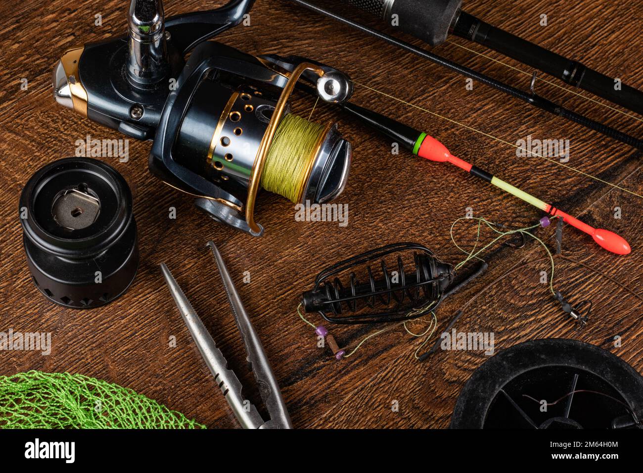 Fishing theme. Frame with reel, rod, fishing buoy, compass, feeder, knife  and on wooden background. Free space Stock Photo - Alamy