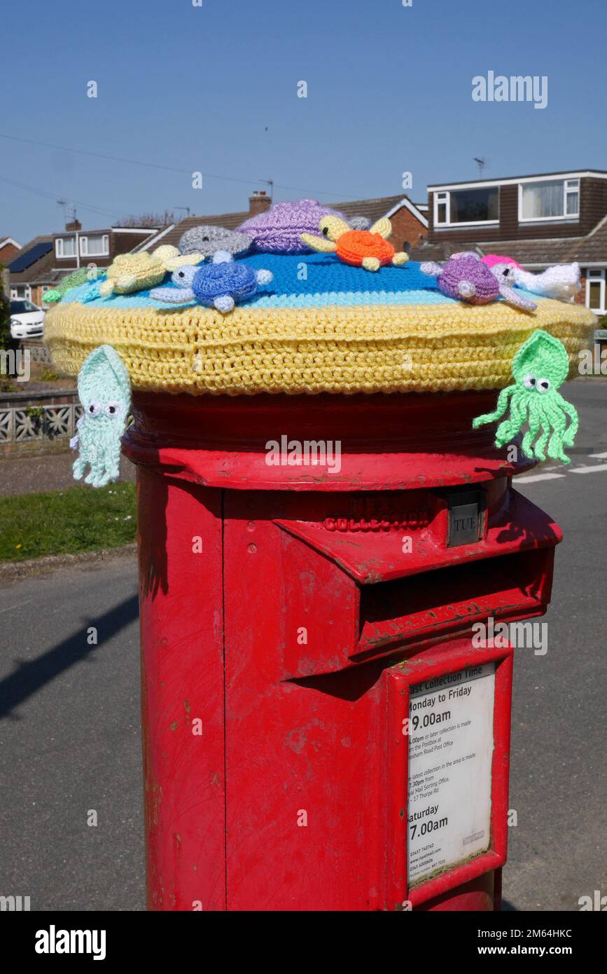 Yarn bombing knitting on a Royal Mail Pillar Box in Residential Street, Norwich, Norfolk, England, UK Stock Photo