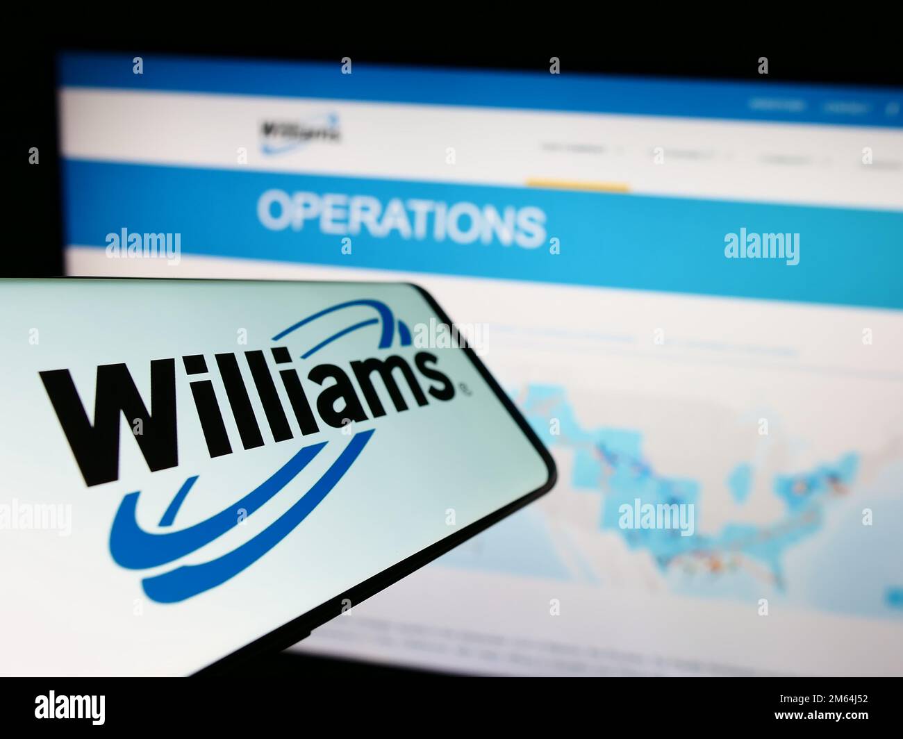 Cellphone with logo of American energy company Williams Companies Inc. on screen in front of website. Focus on center-left of phone display. Stock Photo