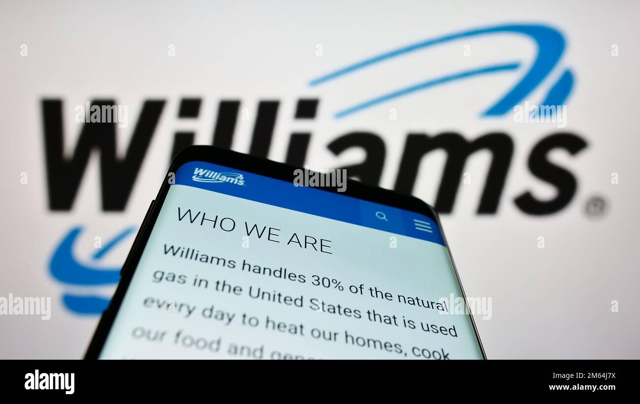 Mobile phone with webpage of US energy company Williams Companies Inc. on screen in front of business logo. Focus on top-left of phone display. Stock Photo