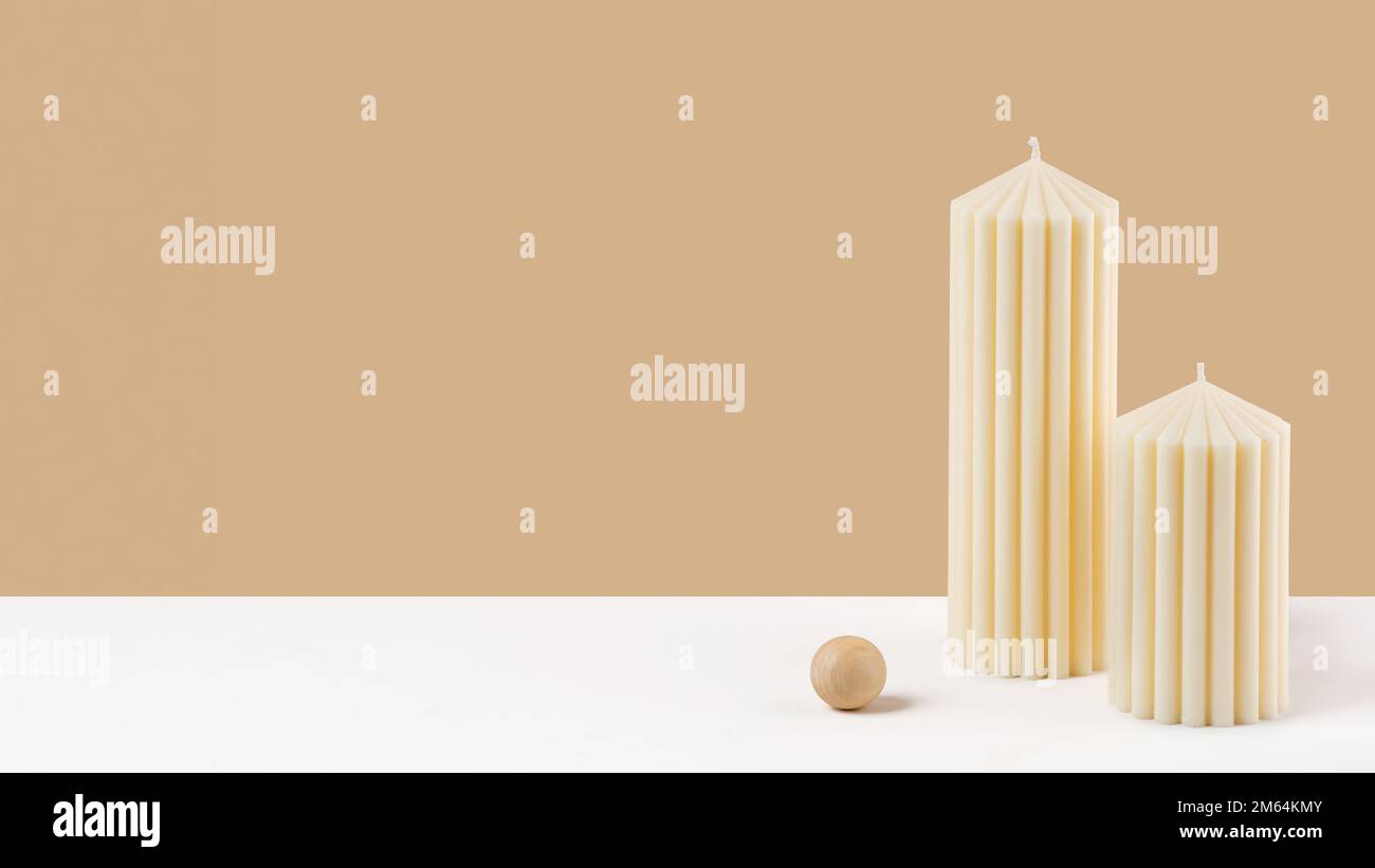 Handmade olive wax pillar candle on a neutral pastel and white background. Sustainability vegan