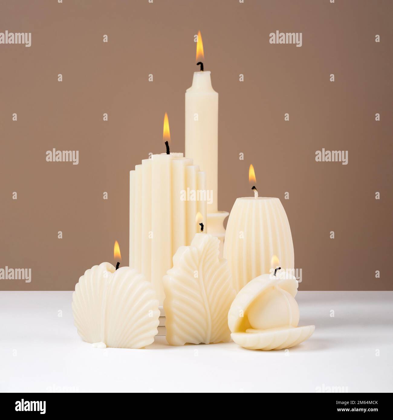 Handmade olive wax different forms burning candle on a duotone brown