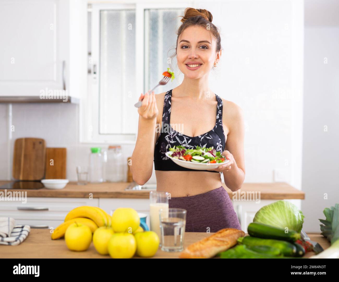 Sportive woman eating vegetable salad at home Stock Photo