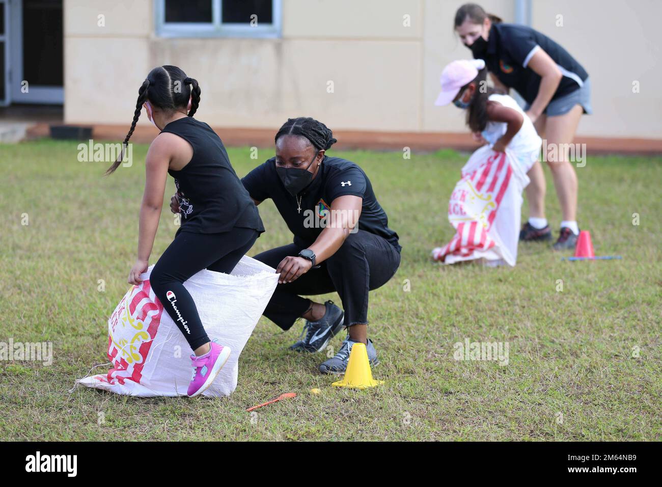 U.S. Marine Corps Gunnery Sgt. Shantavia Wilson, the protocol chief for Marine Corps Base Camp Blaz, assists with a sack race at Liguan Elementary School during a field day event in Dededo, Guam, April 1, 2022. Marines from the base assisted the school in facilitating various relay races as an opportunity to engage with the local community and continue to foster the relationship between the Marine Corps and Liguan Elementary School. Stock Photo