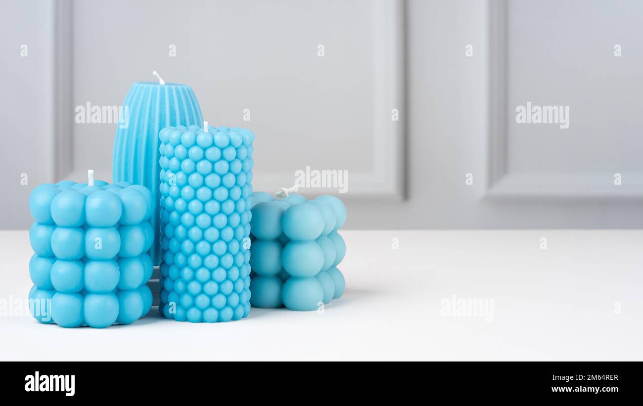 Handmade olive wax different forms blue color candle on a on the white table at home